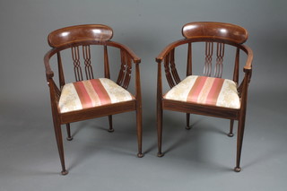 A pair of Edwardian mahogany elbow chairs with horseshoe  backs, drop in seats, raised on tapered legs, pad feet