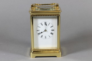 A late 19th Century French gilt brass corniche cased carriage clock, having Roman enamelled dial, lever escapement, the 8 day  movement chiming gong, raised on plinth base 7.5"h x 4"w x  3.5"d