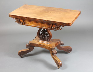 A Regency mahogany tea table with hinged revolving top, raised on a foliate carved lyre support, quadripartite base with scroll feet 28"h x 36"w x 35"d