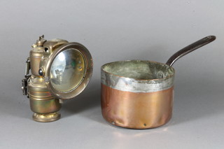 A brass Panther carbide cycle lamp and a 19th Century copper  saucepan with iron handle