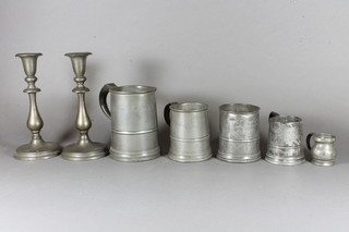 A Victorian quart tankard marked J Barker, 2 Victorian pint tankards marked J Barker, a half gill measure, 1 other pewter  tankard and a pair of pewter candlesticks 9"