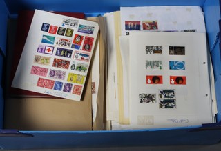 A blue crate containing a red stock book of stamps and a  collection of loose leaf stamps
