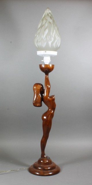 A carved hardwood figural table lamp, a study of a female nude having an opalescent torch shade 37"h