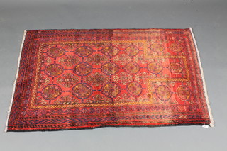 A contemporary Afghan style red ground prayer rug with 14  octagons to the centre 52" x 36"