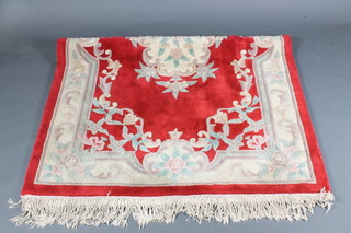 A Chinese red ground and floral patterned rug 95" x 57"