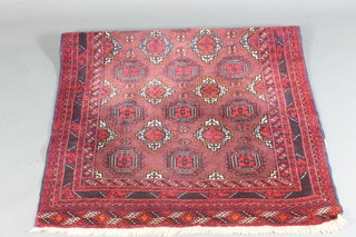 A red ground Belouche rug with 15 stylised octagons to the  centre 70" x 44"