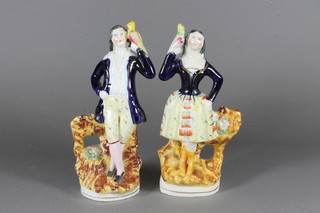 A pair of 19th Century Staffordshire pottery standing lady and gentleman with parrots 9"