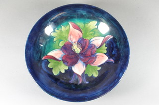 A Moorcroft circular blue glazed charger decorated  columbine, the reverse with signature mark and impressed Made  in England 9.5" diam. ILLUSTRATED