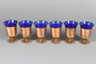 Donald Deskey, a set of 6 blue glass tumblers contained in  coppered frames