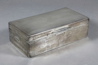 A rectangular silver cigarette box with engine turned decoration and hinged lid, Birmingham 1939, containing a small collection  of coins