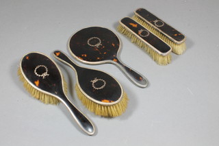 A 5 piece silver and tortoiseshell backed dressing table set comprising pair of hair brushes, pair of clothes brushes and a  hand mirror, London 1939 and 1940