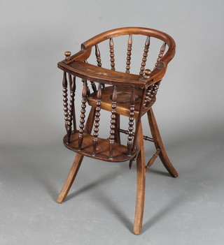 A late 19th Century stained beechwood childs high chair, the  horse shoe back with bobbin turned supports, raised on splayed  legs