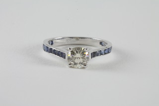 An 18ct white gold solitaire diamond set ring and with sapphires to the shoulders, diamond approx 0.90ct