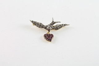 A gold brooch in the form of a dove with heart set rubies