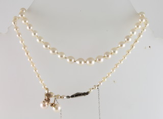 A rope of pearls together with a pair of pearl earrings