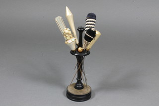 A turned ebony hat pin stand and 7 various hat pins