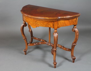 A Louis XV style French walnut and amboyna card table, the  hinged top enclosing a blue baise lined interior, raised on  acanthus leaf carved cabriole legs, scroll feet, 30.5"h x 37.5"w x  18"d