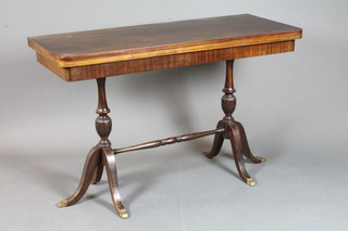 A George III style mahogany folding top side table, raised on turned column supports, tripod bases, 31"h x 47"w x 40"d