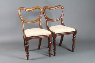 A set of 5 Victorian mahogany buckle back dining chairs, having Trafalgar seats and raised on turned legs