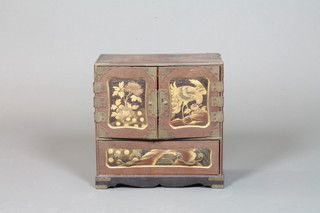 A Japanese Meiji period black and red lacquered Kodansu,  having a pair of fielded panelled cupboard doors decorated with  hirimaki panels of an exotic bird at nest, enclosing an  arrangement of 6 small drawers with a further drawer below on a  shaped plinth base, 14"h x 14"w x 7"d   ILLUSTRATED