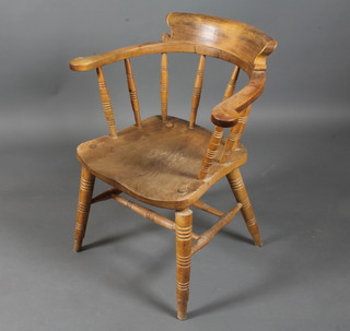 A 19th Century beechwood and elm smokers bow elbow chair  with horse shoe arms above a saddle seat on turned legs