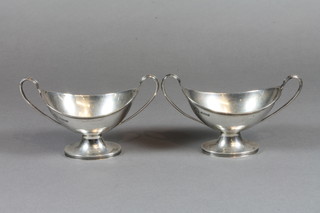 A pair of Edwardian boat shaped twin handled salts raised on spreading feet, Sheffield 1908 4 ozs