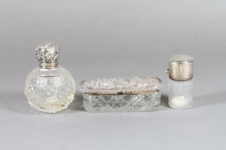 A cylindrical salts bottle with silver lid, Birmingham 1913, a rectangular hobnail cut dressing table jar with embossed silver  lid, Chester 1904 and a globular cut glass dressing table jar with  embossed silver lid
