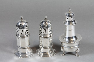 A pair of Georgian style octagonal silver pepperettes, rubbed, together with a silver pepperette Chester marks rubbed, 3 ozs