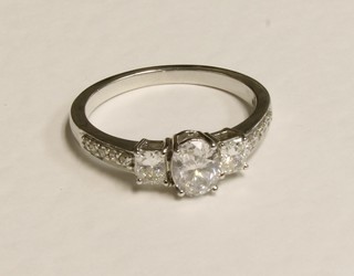 A lady's 18ct white gold oval dress ring set an oval cut diamond supported by 2 diamonds and with 2 diamonds to the shoulders