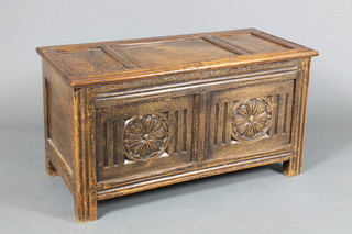 An early 18th Century style oak coffer having hinged panelled  top above a rosette and flute carved front, raised on end stiles,  18.5"h x 35"w x 16"d