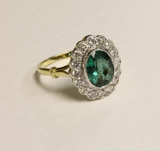 An 18ct yellow gold dress ring set an oval emerald surrounded by diamonds approx. 1.70/0.85ct