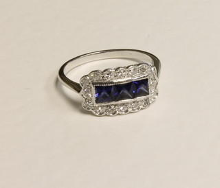 An 18ct white gold dress ring set 3 square cut sapphires  surrounded by diamonds