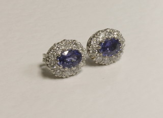 A pair of gold earrings set oval cut sapphires surrounded by  diamonds, approx 1.80/0.80ct