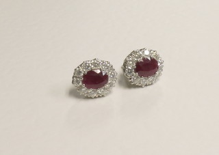 A pair of gold earrings set oval cut rubies surrounded by  diamonds, approx 2.15/1.60ct