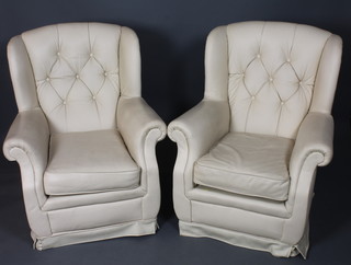 A pair of cream faux leather upholstered open arm chairs