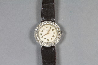 Tudor, a ladies cocktail wristwatch with enamel dial and Arabic numerals, contained in a platinum case, the bezel set diamonds   ILLUSTRATED