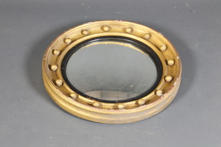 A Regency style gilt wood circular convex wall mirror, having jewelled frame and inset reeded ebony slip 20"diam
