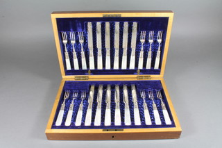 A set of 12 Edwardian silver bladed fruit knives and forks with mother of pearl handles, Sheffield 1900, by John Sanderson,  contained in a walnut case
