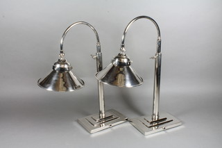 A pair of silver plated adjustable bank style lamps, raised on rectangular bases