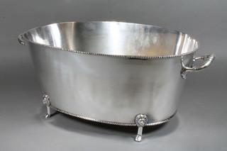 An oval silver plated twin handled wine cooler raised on 4 paw supports 19"
