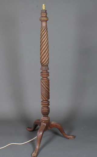 A 19th Century mahogany standard lamp, having a spiral and  foliate carved column support, tripod base with slipper feet 59"h