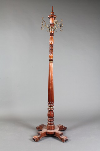 A William IV style reeded mahogany revolving coat stand with  turned and reeded column and quadripartite base 69"h