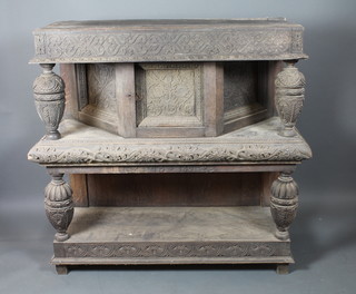 A 19th Century Flemish oak carved court cupboard, the upper section fitted cupboard door flanked by baluster supports and  above a concealed frieze drawer, relief carved with vines, with  second tier below on block feet 52"h x 54"w x 21"d, distressed