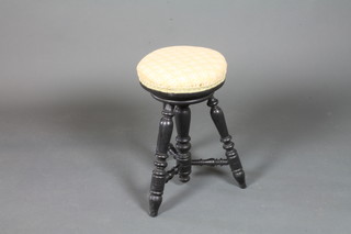 A Victorian ebonised circular adjustable music stool with stuff-over seat, raised on turned legs united by stretchers 20"h x  12"diam.