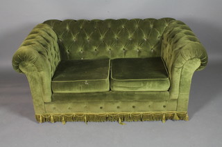 A Victorian style 2 seat Chesterfield settee with dark green  buttoned velvet upholstery, raised on casters, 59"w
