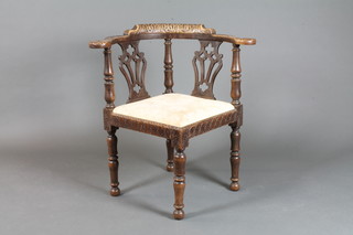 A Victorian carved oak splat back corner chair, heavily carved throughout, raised on turned supports