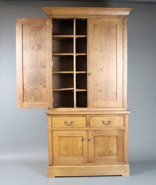 An oak estate style cabinet, the upper section with moulded cornice, the interior fitted various pigeon holes, enclosed by panelled doors, the base fitted 2 short drawers above a double cupboard enclosed by panelled doors 79"h x 42"w x 17"d