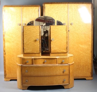 A 1950's Austin Suite of birds eye maple bedroom furniture  comprising gentleman's wardrobe 71"h x 37"w, ladies wardrobe  73"h x 46"w, dressing chest with triple mirror above 3 long and  2 short drawers 24"h x 46"w x 19"d and a pair of bedside  cabinets 24"h x 15"w x 13.5"d