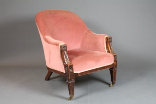 A Victorian carved mahogany show frame tub back chair  upholstered in pink dralon raised on square tapered supports, brass caps and casters
