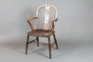 A 19th Century elm Windsor wheel back carver chair with solid seat, on turned supports with H framed stretcher